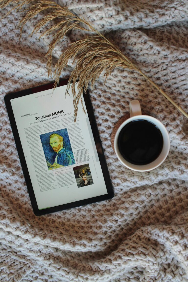 Comfortable morning setup featuring a tablet and coffee cup on a knitted blanket. Perfect for relaxation.